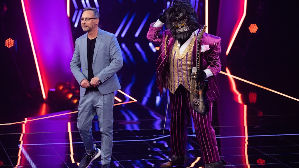 Moderator Matthias Opdenhövel auf der Bühne von The Masked Singer mit dem Gorilla. Welcher Star steckt wohl unter der Maske?
