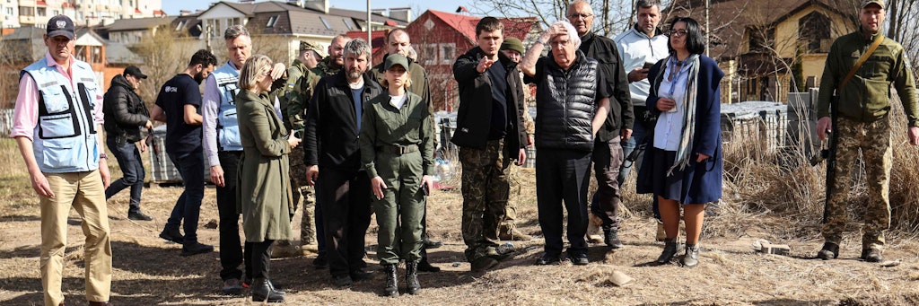UN-Gesandter Martin Griffiths (5. v. r.) reagiert mit Entsetzen vor einem Massengrab, in dem Opfer der Massaker von Butscha in Plastiksäcke gescharrt wurden.