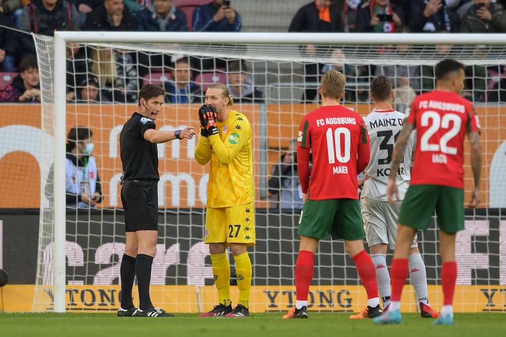 Schiedsrichter Jöllenbeck zeigt auf den Elfmeterpunkt, Mainz-Torwart Zentner kann es nicht fassen.