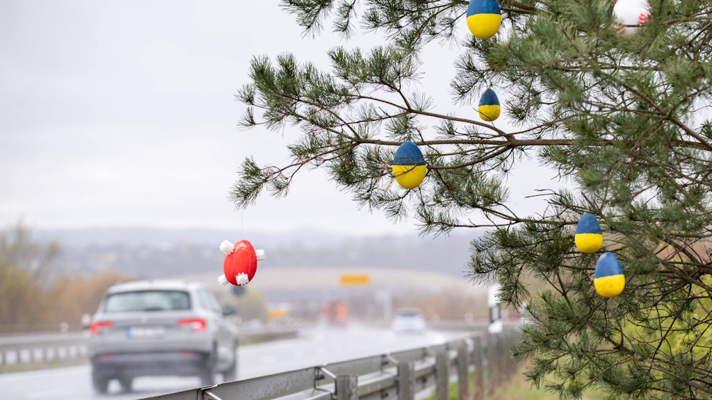 Ostereier in den Farben der ukrainischen Flagge hängen an einem Baum an einer Autobahn in Sachsen.