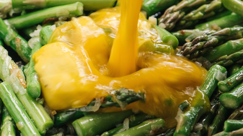 Die Ei-Masse wird bei der Zubereitung der Frittata über den Spargel gegossen.