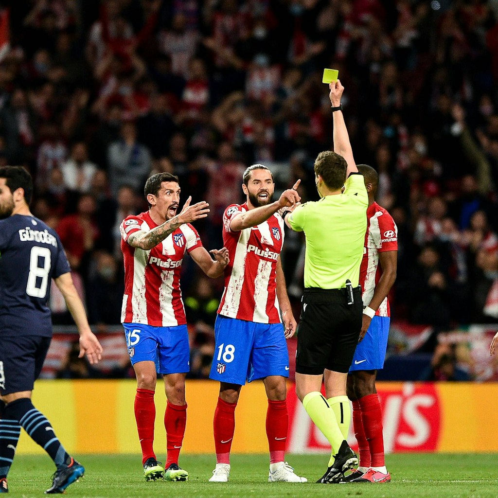 Atléticos Stevan Savic und Felipe protestieren bei Schiri Daniel Siebert wegen einer Gelben Karte.
