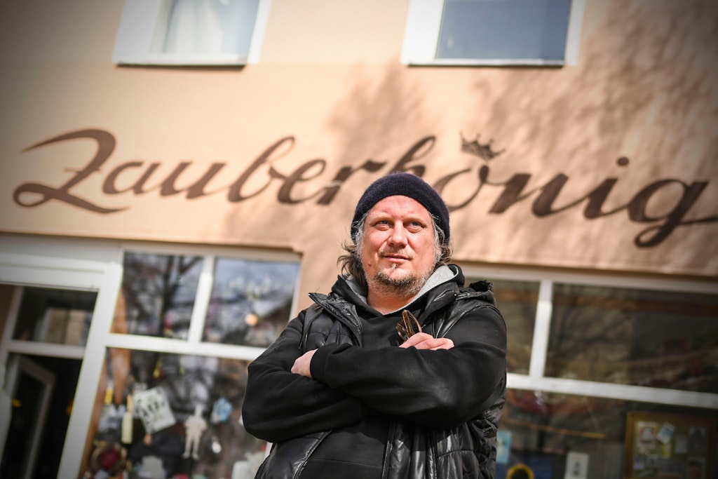 Stefan Tollkmitt vor einem Geschäft für Magierbedarf und Zaubereien in der Weisestraße in Neukölln. Genau davor verläuft auch die ominöse Line auf dem Bürgersteig.