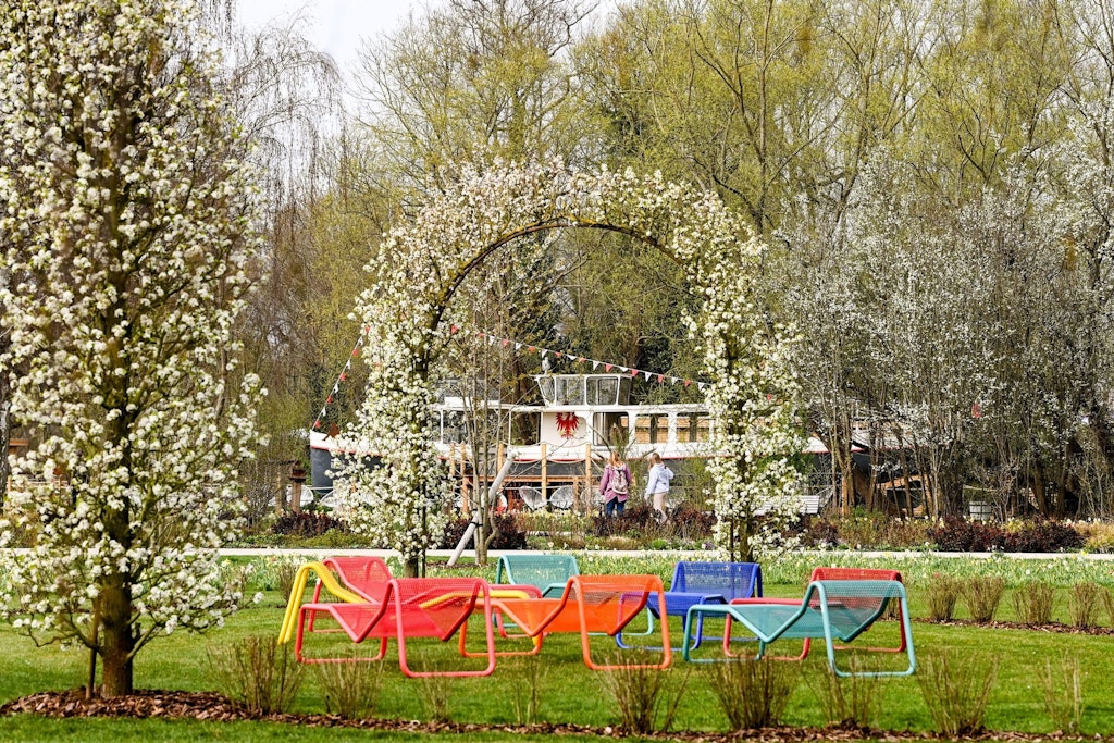 Erste Besucher spazieren zwischen Frühlingsblumen auf dem Gelände der Landesgartenschau in Belitz.