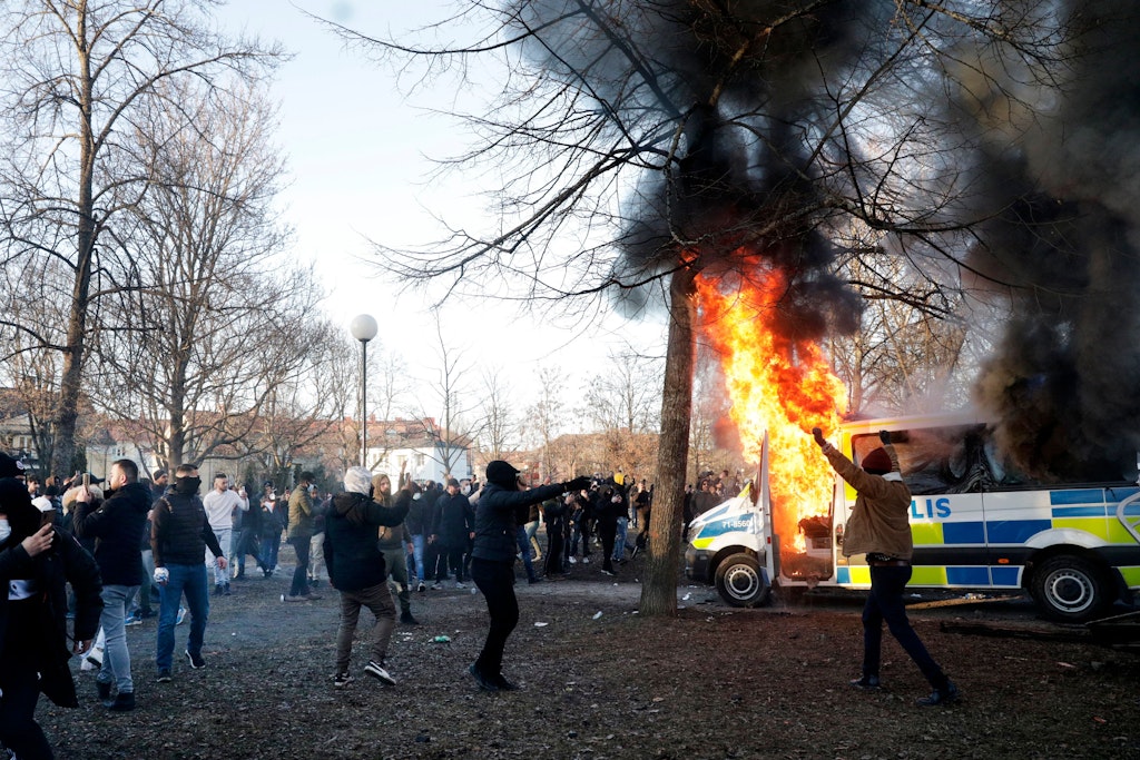 Demonstranten zünden einen Polizeibus im Park Sveaparken in Orebro an.