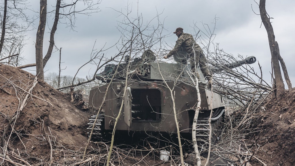 Ein ukrainischer Soldat steigt auf einen Schützenpanzer im Donbass.
