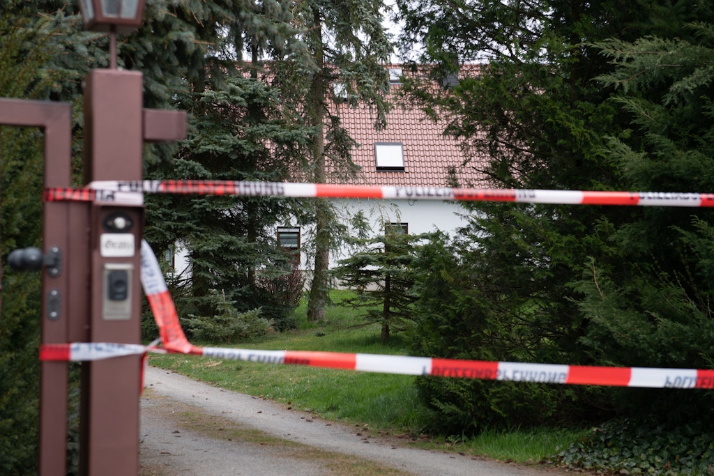 An der Einfahrt des Todeshauses in Chemnitz hängt ein Absperrband. Die Leichen der beiden Paare wurden hier späten Montagabend gefunden.
