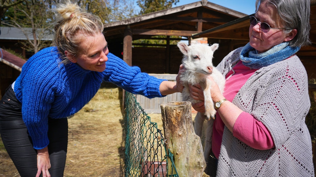 Claudia Kleiner (l.) streichelt ein wenige Tage altes Lamm, das Barbara Brunat, Betreiberin des Erlenhofs, hält.