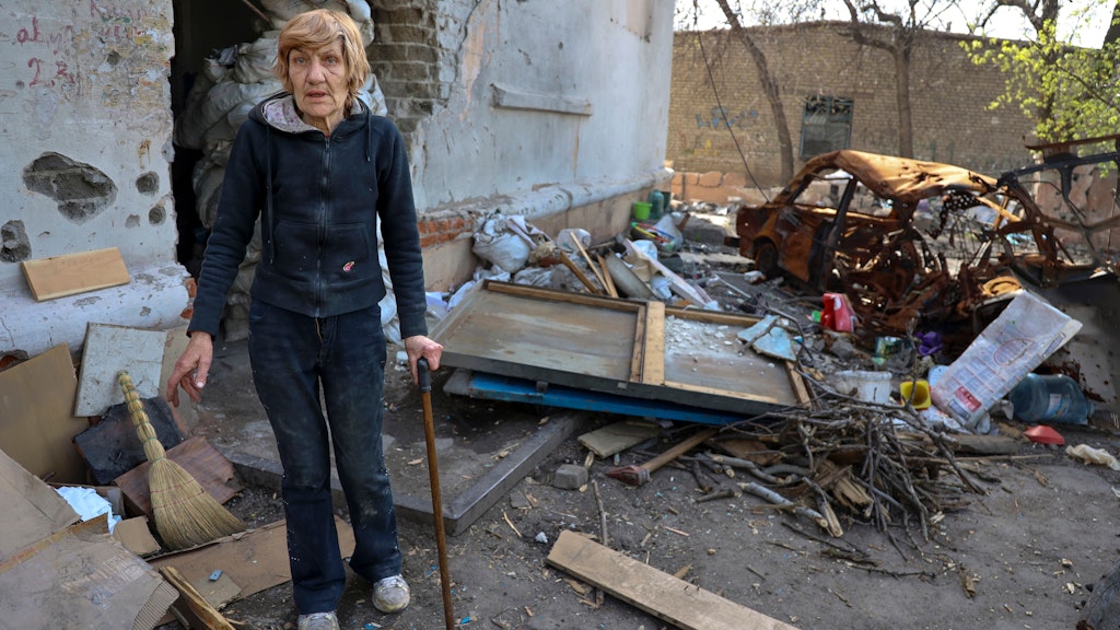 Eine Einheimische steht in der Nähe eines beschädigten Wohnhauses, das bei schweren Kämpfen in einem von den von Russland unterstützten Separatisten kontrollierten Gebiet in Mariupol, Ukraine, beschädigt wurde.