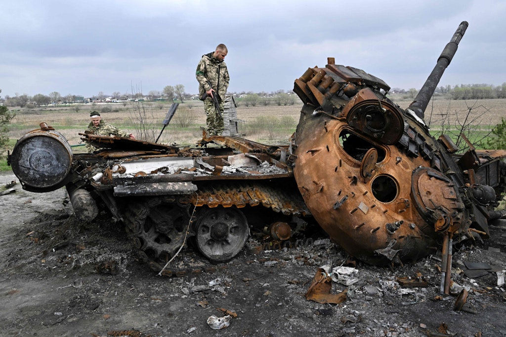 Ein ukrainischer Soldat auf einem zerstörten russischen Panzer in Rusaniv, ein Dorf nahe Kiew.
