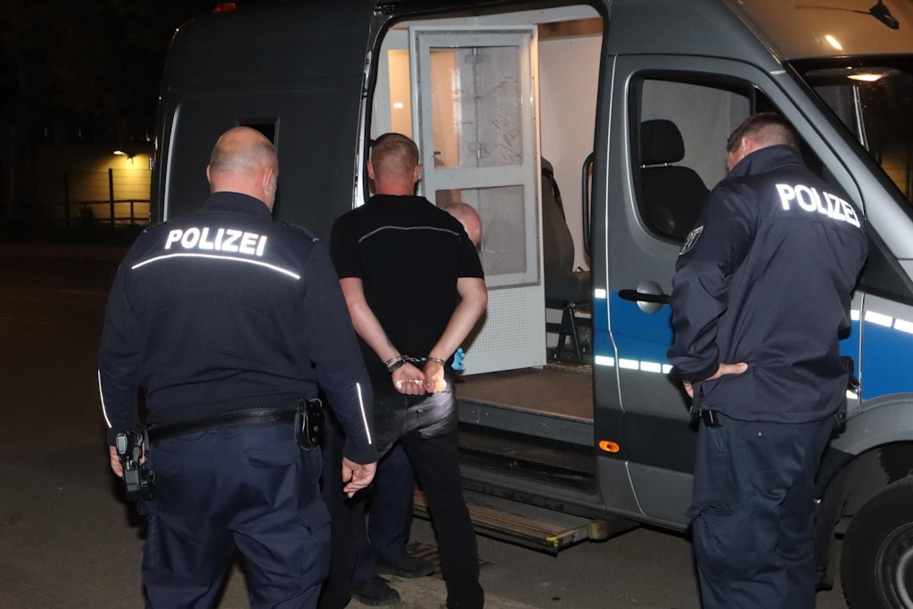 Der betrunkene Autofahrer wird gefesselt abgeführt.