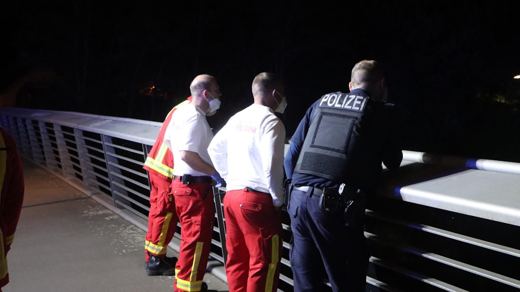 Feuerwehrleute und ein Polizist suchen den Teltowkanal ab. Hier war der betrunkene Autofahrer reingesprungen.