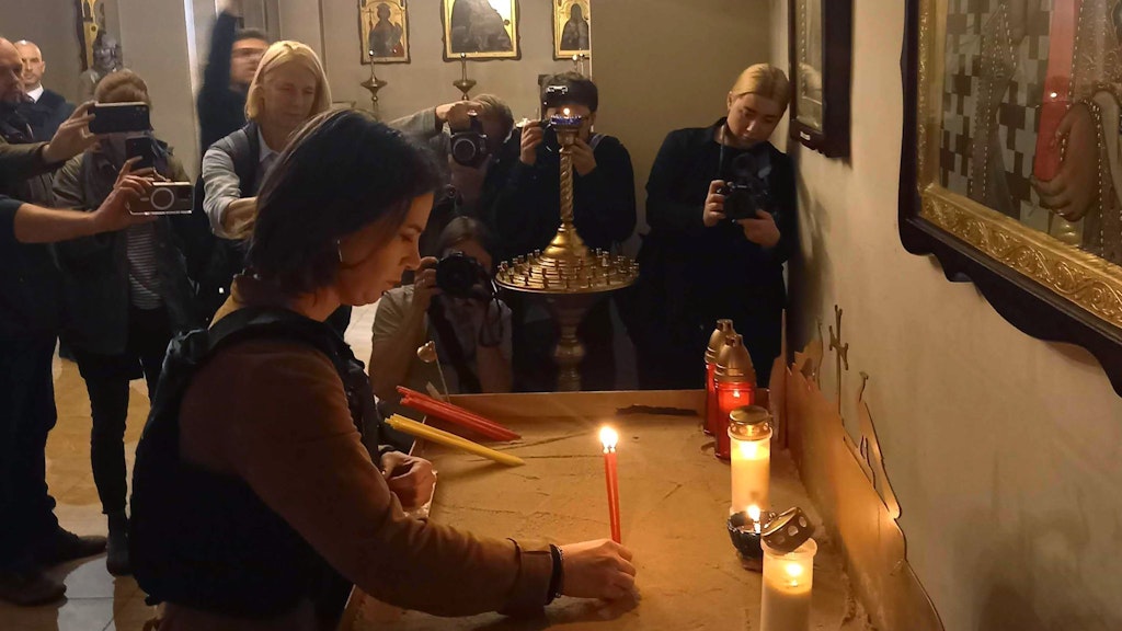 Die deutsche Außenministerin Annalena Baerbock entzündet in einer Kirche in Butscha eine Kerze für die Opfer des Krieges.