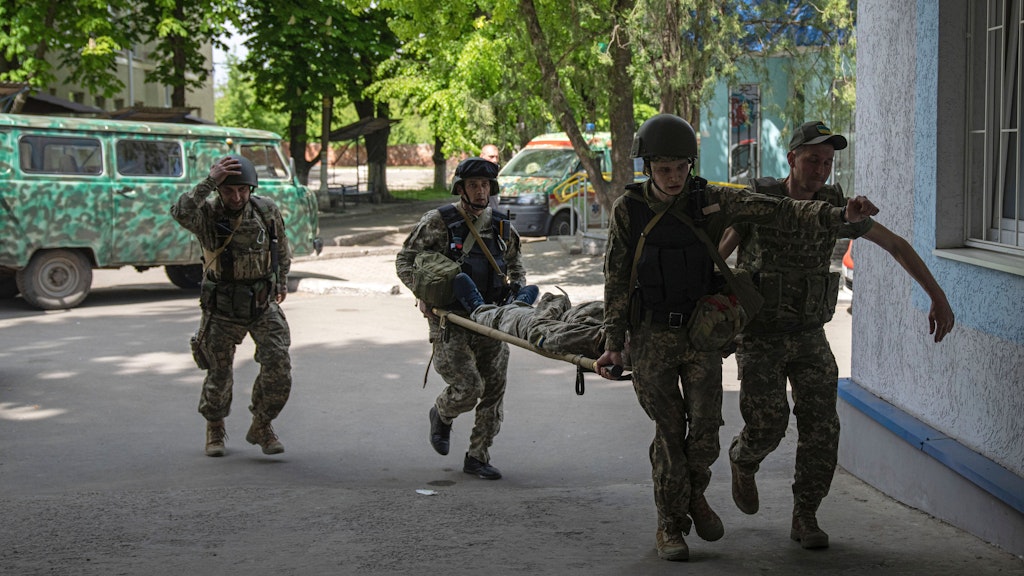 Ukrainische Soldaten bringen einen verwundeten Kameraden in Sicherheit.