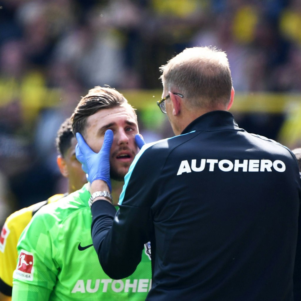 Herthas Mannschaftsarzt Dr. Ulrich Schleicher richtet die gebrochene Nase von Marcel Lotka. Der Keeper spielte weiter.