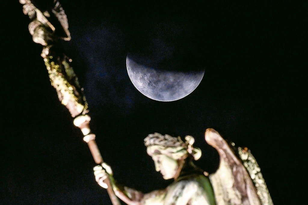 Der Mond ist während einer partiellen Mondfinsternis hinter der Quadriga des Brandenburger Tors zu sehen.