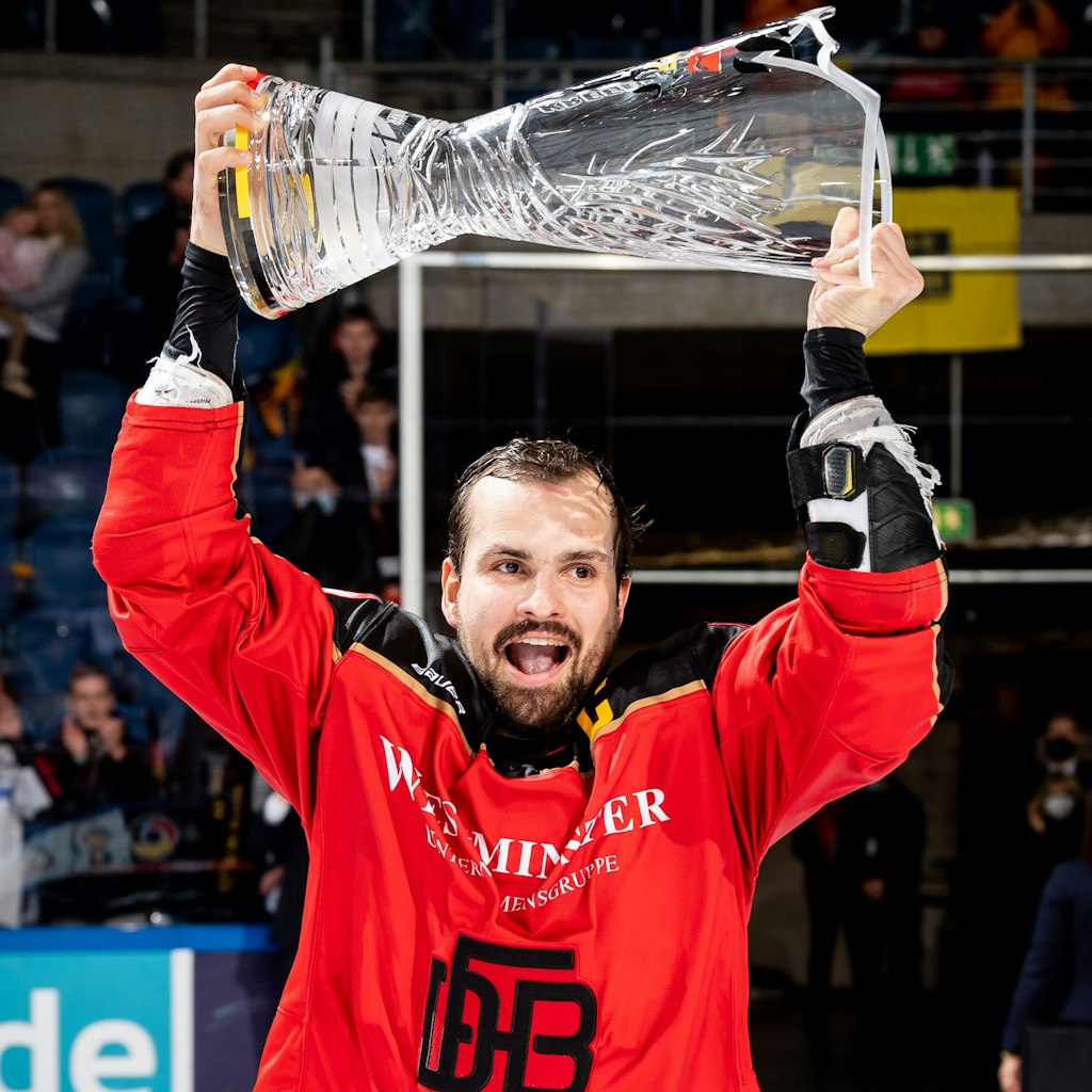 Marco Nowak stemmt beim Deutschland-Cup 2021 den Gewinner-Pokal.