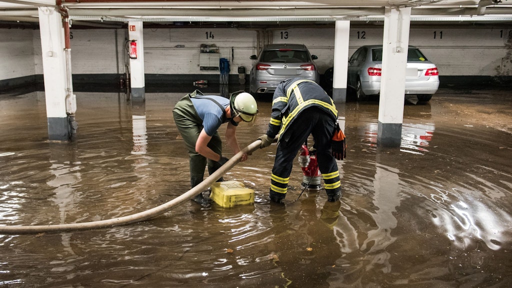 Feuerwehrleute pumpen in Hamburg Wasser aus einer überfluteten Tiefgarage ab.