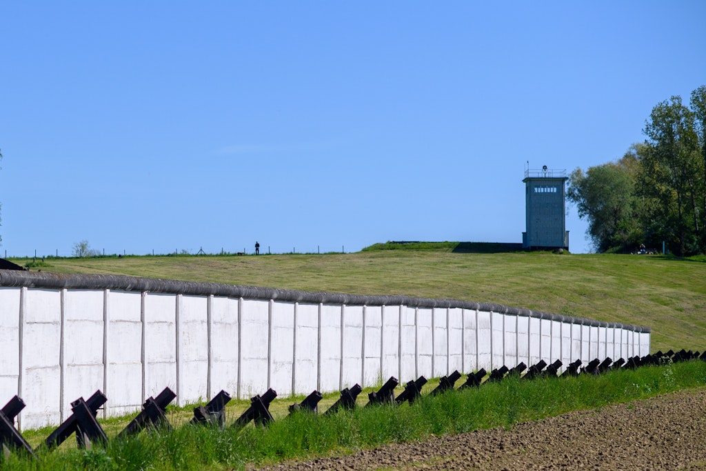 Hötensleben in Sachsen-Anhalt: Der ehemalige Turm der Führungsstelle oberhalb der alten Grenzmauer und den Kraftfahrzeughöckern. Die Bauwerke gehören heute zum „Grenzdenkmal Hötensleben“.