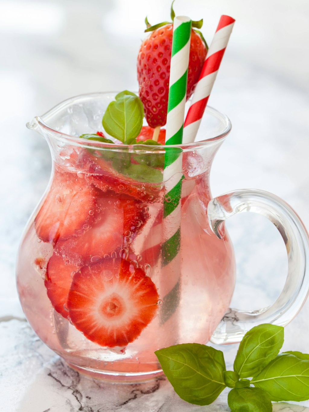 Hausgemachte Bowle mit frischen Erdbeeren und Basilikum oder Minze.