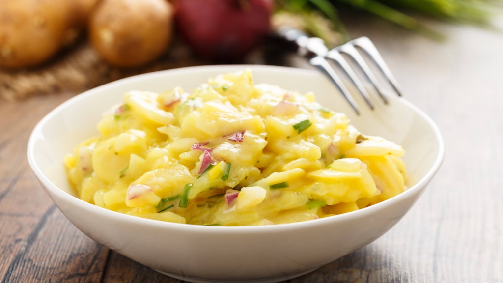 Dieser Kartoffelsalat ist leicht zu variieren: Wer sich vegetarisch ernährt, kann den Schinken aus dem Rezept auch einfach weglassen, dafür ein paar Würfelchen rote Zwiebeln zufügen.