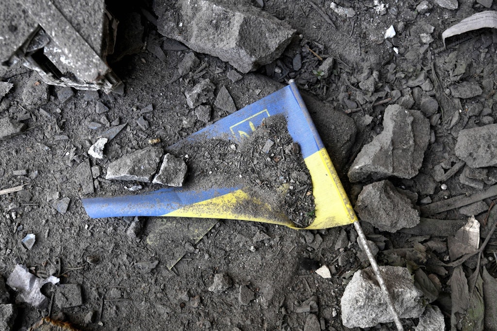 Eine ukrainische Flagge liegt nach einem Raketeneinschlag in Charkiw in den Trümmern.