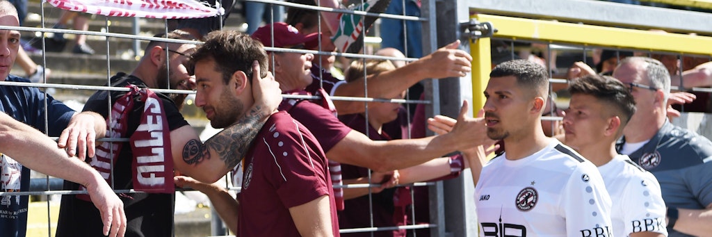 BFC-Stürmer Christian Beck (l.) schiebt nach dem Aufstiegs-K.-o. in Oldenburg Frust. Da helfen auch nicht die aufmunternden Worte der mitgereisten Dynamo-Fans.