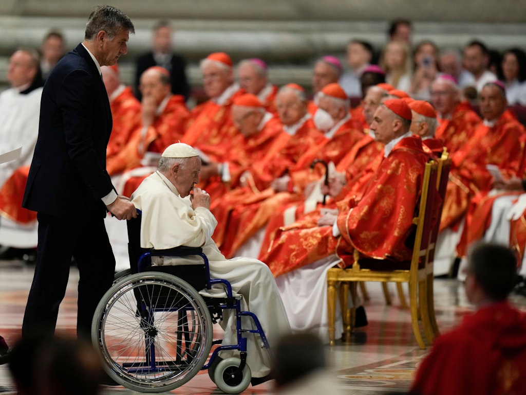 Der päpstliche Kammerdiener Sandro Mariotti schiebt Franziskus im Rollstuhl aus dem Petersdom. Der Papst hatte dort die Predigt der Pfingstmesse gehalten.