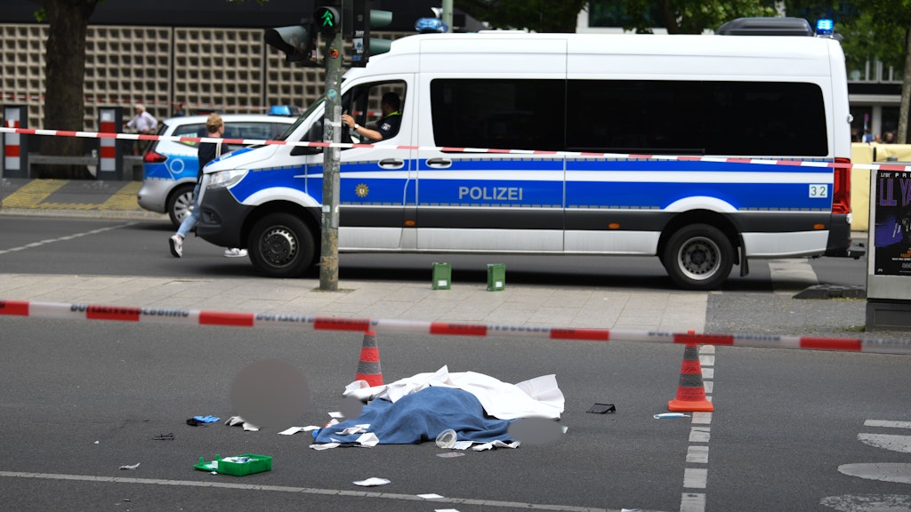 Das Todesopfer liegt abgedeckt auf der Straße.