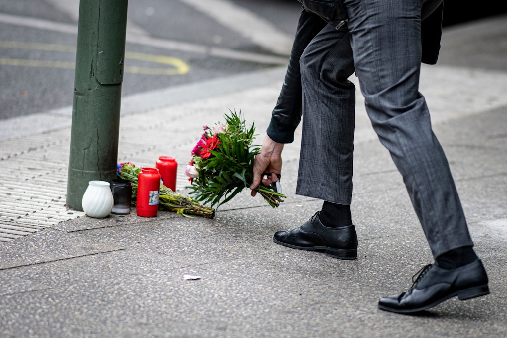 Ein Mann legt Blumen auf den Bürgersteig an der Tauentzienstraße auf den Boden. Am Vortag war ein 29-jähriger hier mit seinem Auto in der Nähe der Berliner Gedächtniskirche in eine Schülergruppe aus Hessen gefahren, deren Lehrerin ums Leben kam.