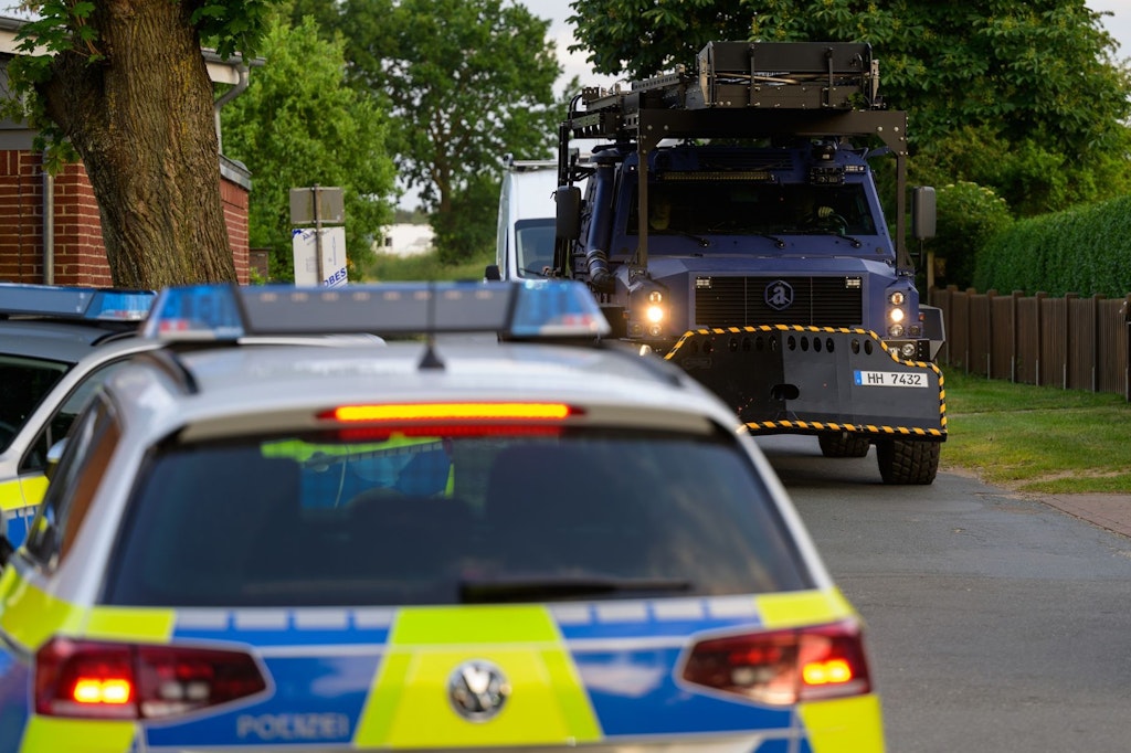 Ein Streifenwagen und ein gepanzertes Spezialfahrzeug der Polizei an der Einsatzstelle.