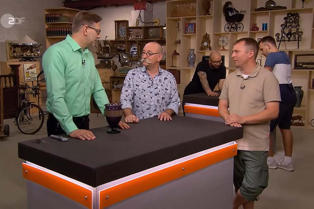 Kandidat Sebastian Klingner (39) brachte eine Vase vom Flohmarkt zu Bares für Rares - hier schauen sich Detlev Kümmel und Moderator Horst Lichter das Stück an.