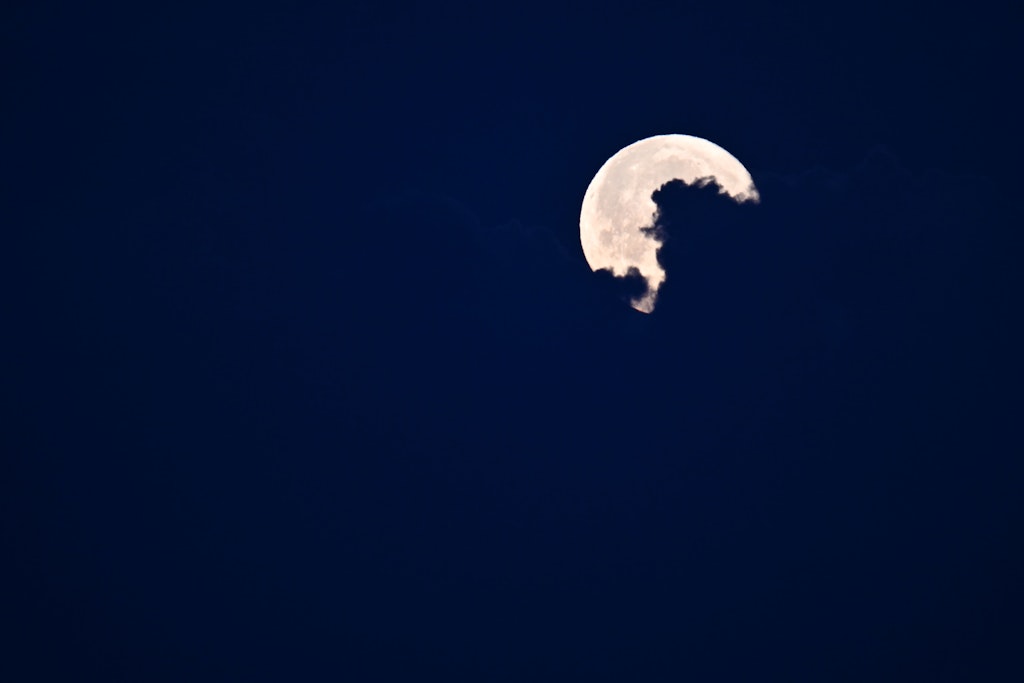 Der Mond wird von einer Wolke verdeckt.