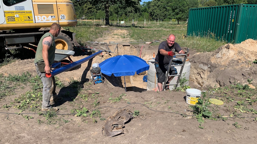 Sven Michaelis und Ronald Kühn (r.) von der Firma Pumpen-Lehmann sind bei brütender Hitze dabei, den Waldgarten ans Wassernetz anzuschließen.