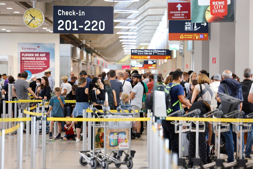 Dicht gedrängt warten Passagiere am Samstag in einer Schlange von mehreren hundert Metern für die Sicherheitskontrolle am Flughafen Köln Bonn an - die wenigsten mit Corona-Maske.