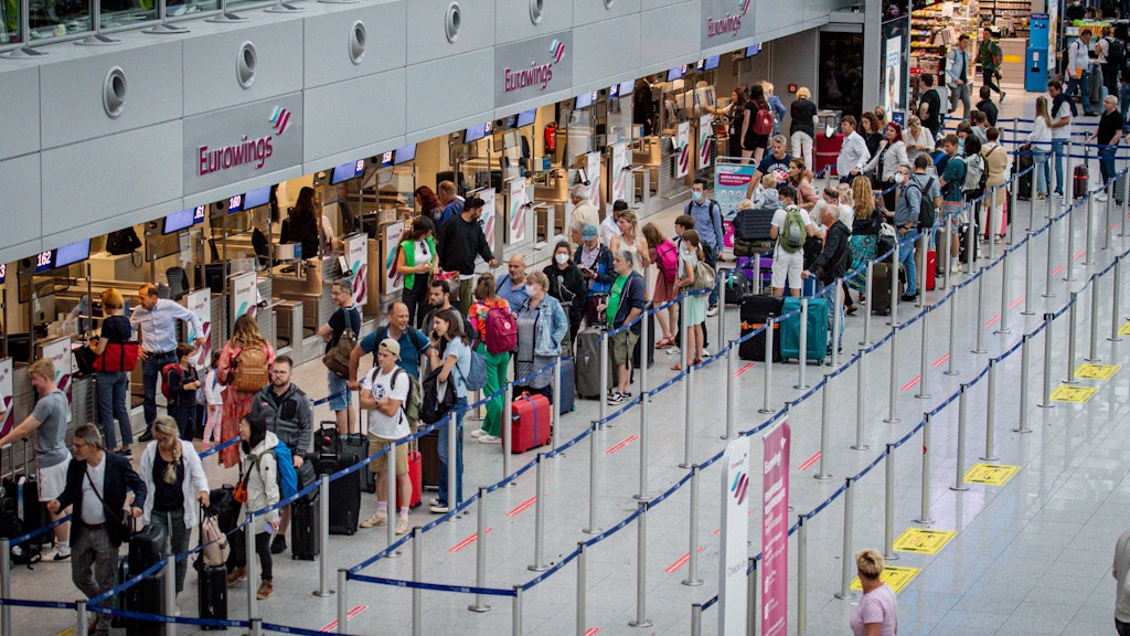 Chaos am Flughafen: Reisende wollen in den Urlaub fliegen und müssen in langen Warteschlangen stehen.