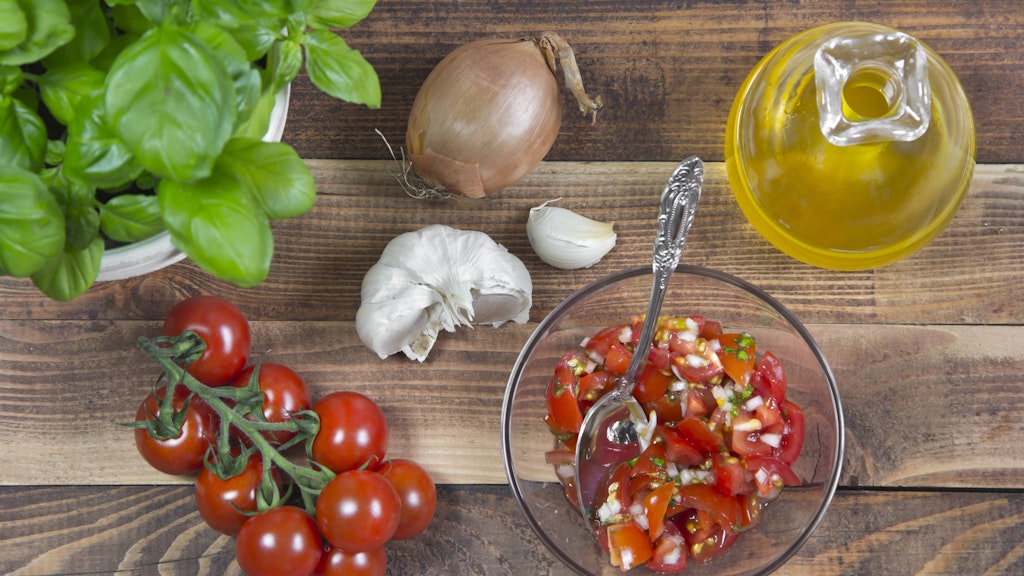 Wer mag, kann dem Dressing vom Tomatensalat noch etwas Knoblauch beigeben.