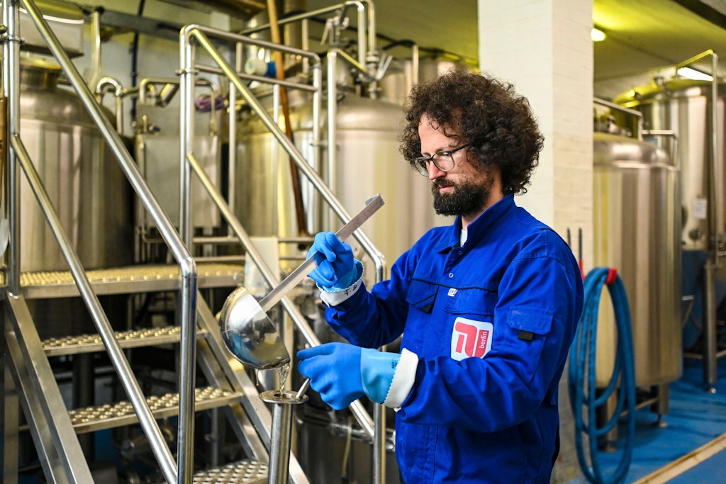 Jonas Mömken zieht eine Probe, um die Stammwürze nach der Kochung zu bestimmen.