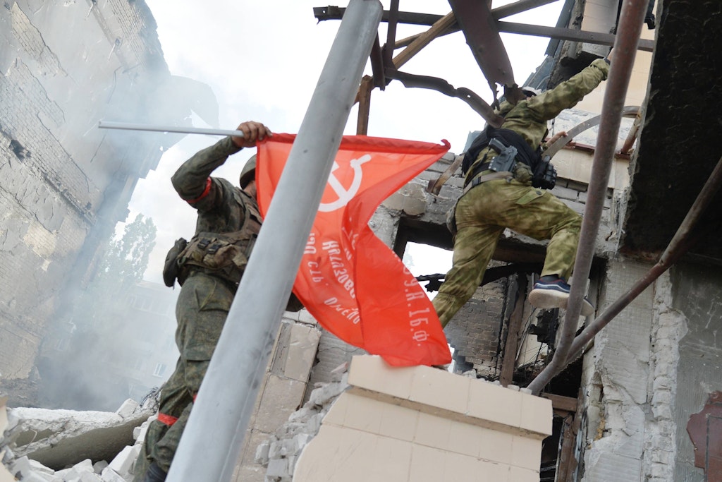 Tschetschenische Soldaten befestigen in der zu großen Teilen zerstörten ostukrainischen Stadt Lyssytschansk ein Banner der Sowjetunion an einem öffentlichen Gebäude.
