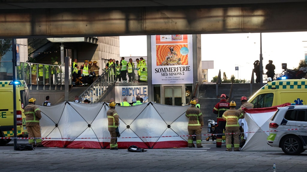 Rettungskräfte behandeln Opfer der Schüsse in einem Einkaufszentrum in Kopenhagen hinter einem Sichtschutzzaun.