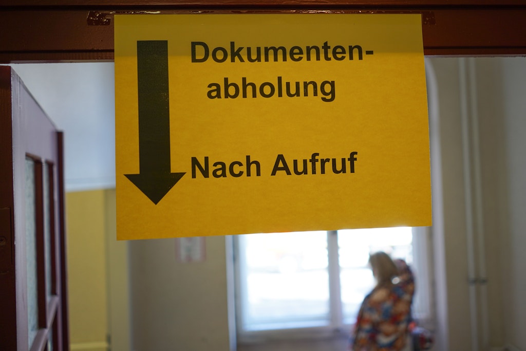 Auf einem Transparent im Bürgeramt Pankow steht „Dokumentenabholung: Nach Aufruf“. Noch ticken viele Berliner Verwaltungen analog. Das soll ändern.