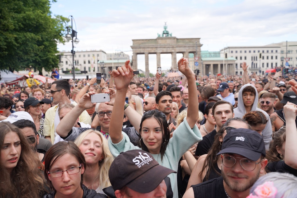 Unter dem Motto „Rave The Planet“ zieht eine Parade aus Technofans tanzend am Brandenburger Tor vorbei.