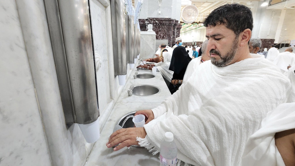 Der Iraker Adam Mohammed, Hadsch-Pilger, nimmt Wasser aus dem heiligen Brunnen von Zamzam, einer Süßwasserquelle unter dem Hof der Großen Moschee.