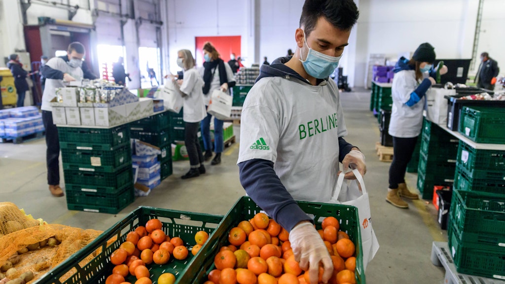 Viele Berliner kommen nur noch über die Runden, weil sie von der Berliner Tafel versorgt werden. Hier packen in einer Halle des Berliner Großmarkts ehrenamtliche Helfer der Berliner Tafel Lebensmittel in Tüten.