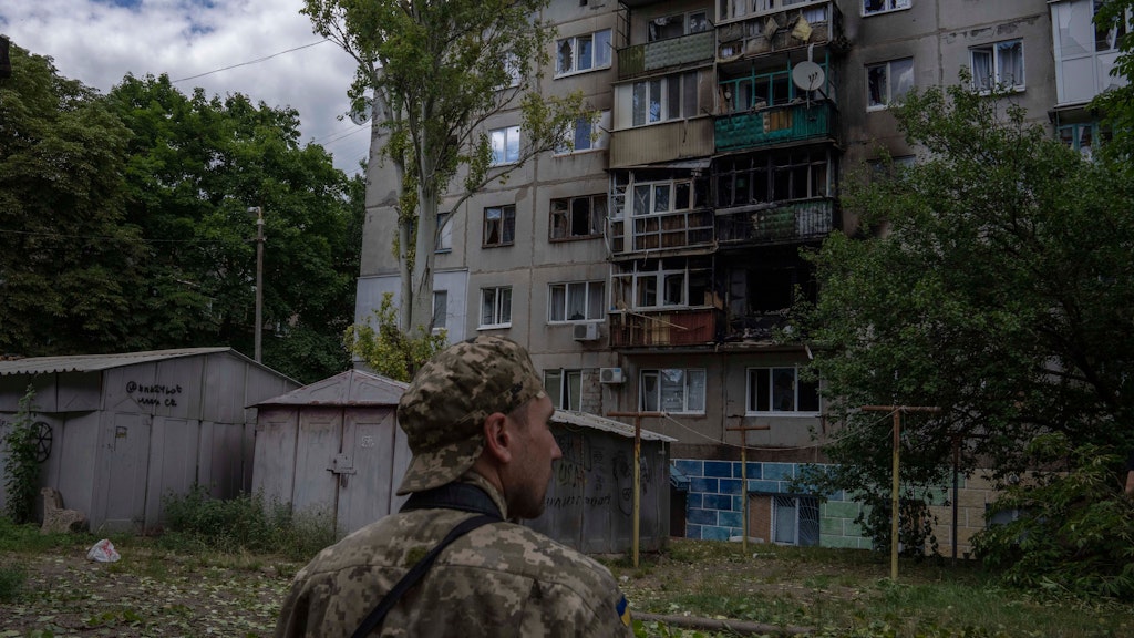 Kramatorsk: Ein ukrainischer Soldat betrachtet ein fünfstöckiges Wohnhaus, das bei einem Raketenangriff auf ein Wohngebiet beschädigt wurde.