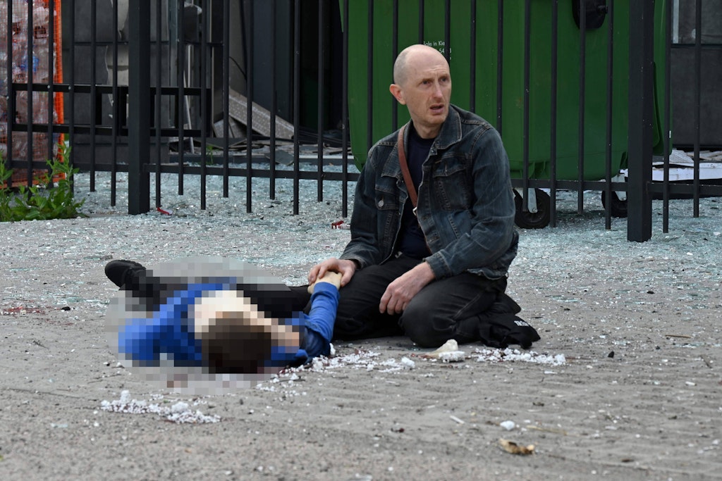 Ein Vater hält die Hand seines toten Sohnes in Charkiw.
