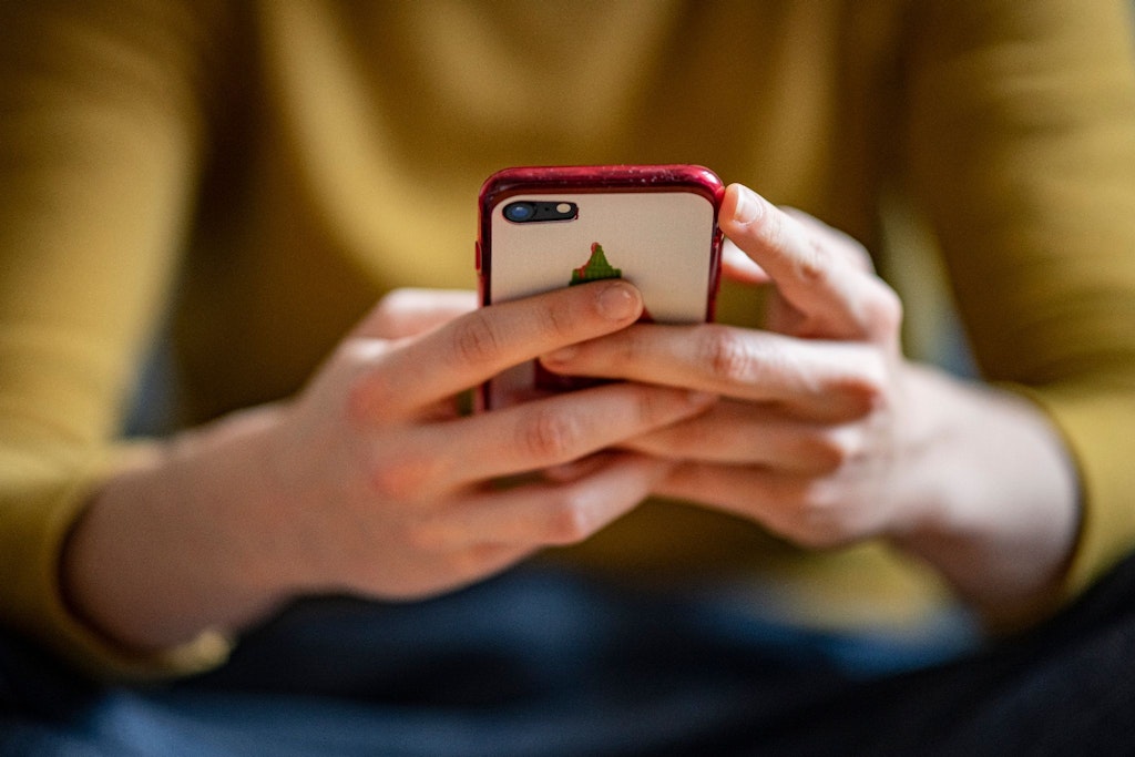 Eine junge Frau hält ein Smartphone in der Hand. In Berlin müsste es viel mehr kostenloses WLAN geben.