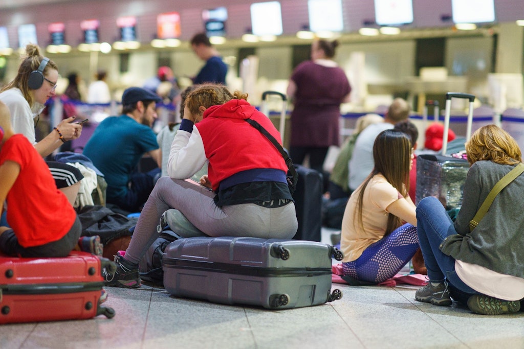 Passagiere warten am frühen Morgen am Frankfurter Flughafen auf eine Reisemöglichkeit.
