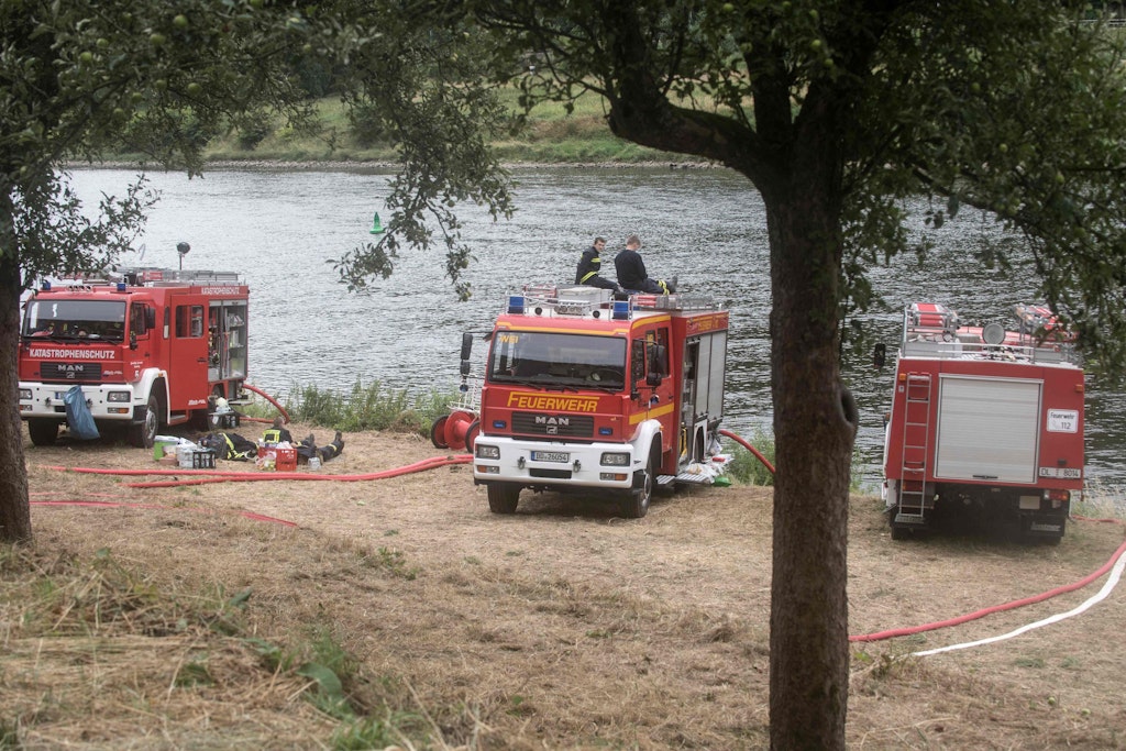 Feuerwehrleute ruhen sich an der Elbe nahe des Örtchens Schmilka in der Sächsischen Schweiz aus.