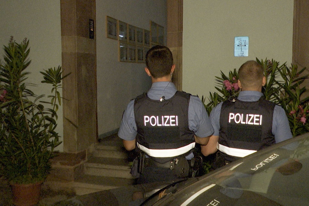 Polizeibeamte stehen vor dem Eingang des Hauses, wo sich die Tragödie abspielte.
